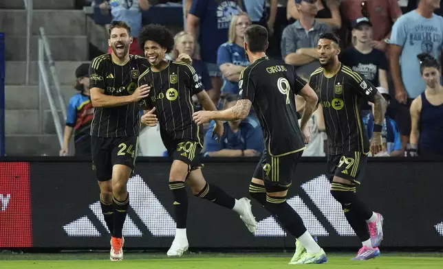 Los Angeles FC attacker David Martínez (30) celebrates with teammates after scoring a goal during the first half of an MLS soccer match against Sporting Kansas City Saturday, Oct. 5, 2024, in Kansas City, Kan. (AP Photo/Charlie Riedel)