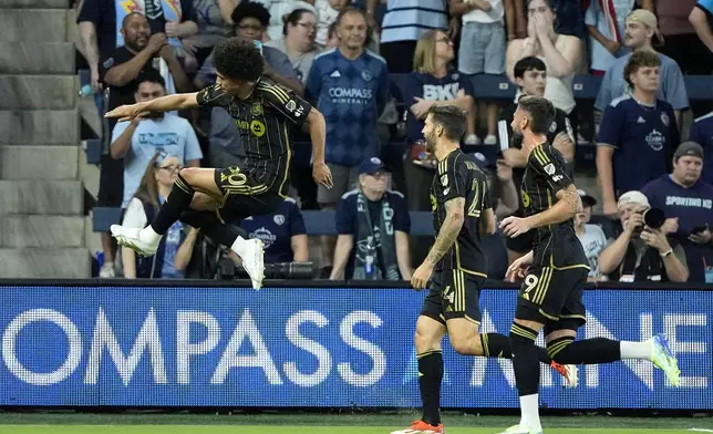 Los Angeles FC attacker David Martínez, left, celebrates with teammates after scoring a goal during the first half of an MLS soccer match against Sporting Kansas City Saturday, Oct. 5, 2024, in Kansas City, Kan. (AP Photo/Charlie Riedel)