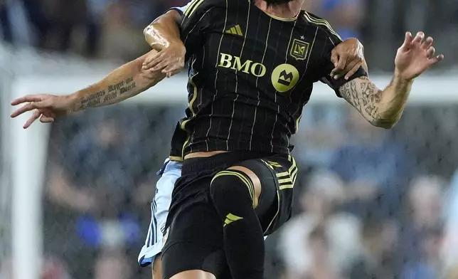 Sporting Kansas City defender Joaquin Fernandez, back, and Los Angeles FC attacker Olivier Giroud battle for the ball during the first half of an MLS soccer match Saturday, Oct. 5, 2024, in Kansas City, Kan. (AP Photo/Charlie Riedel)