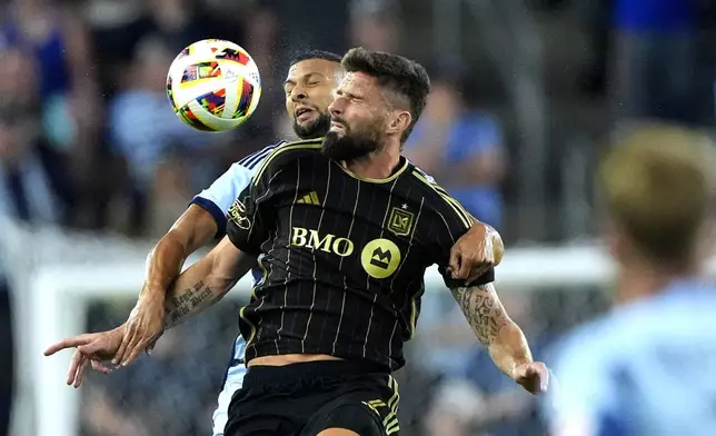 Sporting Kansas City defender Joaquin Fernandez, back, and Los Angeles FC attacker Olivier Giroud battle for the ball during the first half of an MLS soccer match Saturday, Oct. 5, 2024, in Kansas City, Kan. (AP Photo/Charlie Riedel)