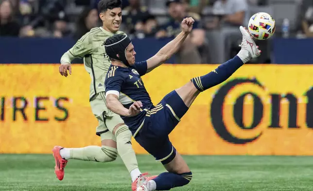 Vancouver Whitecaps' Bjorn Inge Utvik, right, and Los Angeles FC's Omar Campos, top, vie for the ball during the first half of an MLS soccer match in Vancouver, British Columbia, Sunday, Oct. 13, 2024. (Ethan Cairns/The Canadian Press via AP)