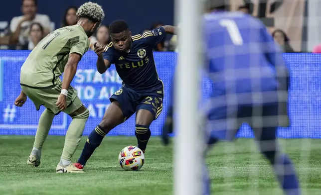 Vancouver Whitecaps' Deiber Caicedo, center, prepares to kick the ball, missing the net, as Los Angeles FC's Timothy Tillman, left, and goalkeeper Hugo Lloris, right, watch during second half MLS soccer action in Vancouver, British Columbia, Sunday, Oct. 13, 2024. (Ethan Cairns/The Canadian Press via AP)