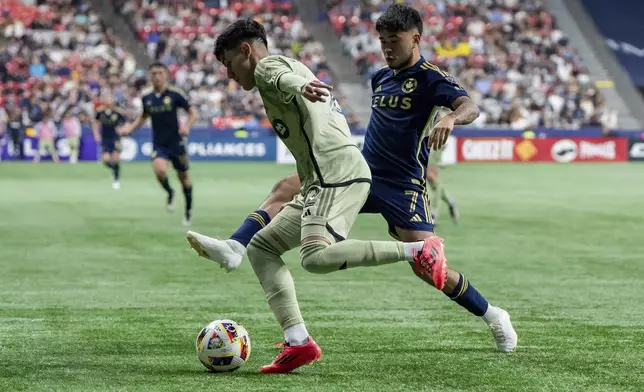 Los Angeles FC's Omar Campos, left, and Vancouver Whitecaps' Ryan Raposo, right, vie for the ball during second half MLS soccer action in Vancouver, British Columbia, Sunday, Oct. 13, 2024. (Ethan Cairns/The Canadian Press via AP)