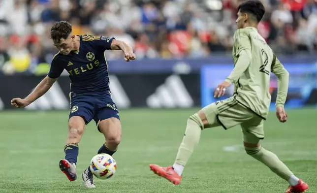 Vancouver Whitecaps' Sebastian Berhalter, left, kicks the ball as Los Angeles FC's Omar Campos (2) defends during second half MLS soccer action in Vancouver, British Columbia, Sunday, Oct. 13, 2024. (Ethan Cairns/The Canadian Press via AP)