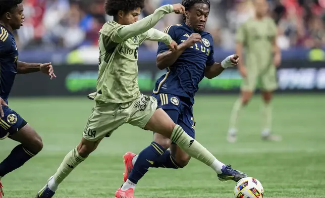 Los Angeles FC's David Martinez, center left, and Vancouver Whitecaps' Levonte Johnson, right, vie for the ball during the first half of an MLS soccer match in Vancouver, British Columbia, Sunday, Oct. 13, 2024. (Ethan Cairns/The Canadian Press via AP)