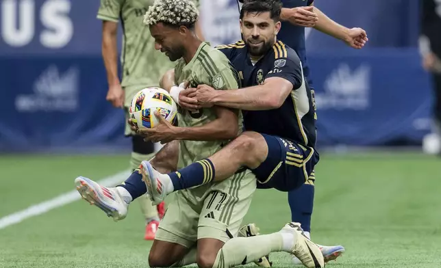 Vancouver Whitecaps' Brian White, right, jumps on Los Angeles FC's Timothy Tillman, left, after a whistle during the first half of an MLS soccer match in Vancouver, British Columbia, Sunday, Oct. 13, 2024. (Ethan Cairns/The Canadian Press via AP)