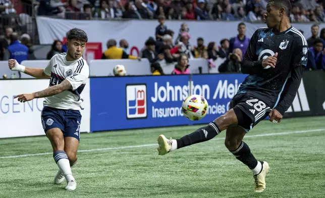 Minnesota United's Jefferson Diaz, right, blocks Vancouver Whitecaps' Ryan Raposo's shot during the second half of an MLS soccer game, Saturday, Oct. 5, 2024 in Vancouver, British Columbia. (Ethan Cairns/Canadian Press via AP)