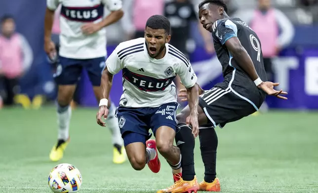 Vancouver Whitecaps' Pedro Vite (45) is tripped by Minnesota United's Kelvin Yeboah (9) during the second half of an MLS soccer game, Saturday, Oct. 5, 2024 in Vancouver, British Columbia. (Ethan Cairns/Canadian Press via AP)