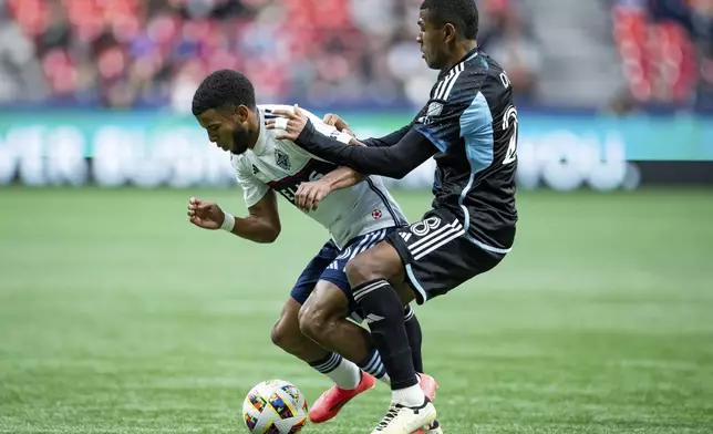 Minnesota United's Jefferson Diaz, right, pushes Vancouver Whitecaps' Pedro Vite, left, during the second half of an MLS soccer game, Saturday, Oct. 5, 2024 in Vancouver, British Columbia. (Ethan Cairns/Canadian Press via AP)