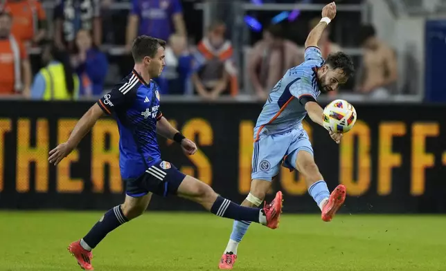 New York City FC forward Kevin O'Toole, right, clears the ball against FC Cincinnati midfielder Pavel Bucha, left, during the second half of a first-round soccer match of the MLS Cup playoffs, Monday, Oct. 28, 2024, in Cincinnati. (AP Photo/Carolyn Kaster)