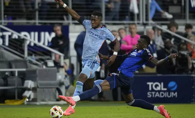 New York City FC midfielder Andrés Perea, left, and FC Cincinnati defender Teenage Hadebe right, fight for the ball during the second half of a first-round soccer match of the MLS Cup playoffs, Monday, Oct. 28, 2024, in Cincinnati. (AP Photo/Carolyn Kaster)