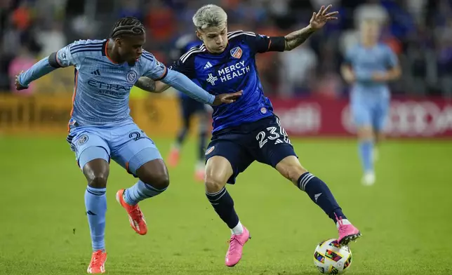 New York City FC defender Tayvon Gray, left, and FC Cincinnati midfielder Luca Orellano fight for the ball during the first half of a first-round soccer match of the MLS Cup playoffs, Monday, Oct. 28, 2024, in Cincinnati. (AP Photo/Carolyn Kaster)