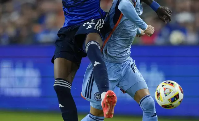 FC Cincinnati defender Teenage Hadebe, left, and New York City FC midfielder Hannes Wolf, right, fight for the ball during the first half of a first-round soccer match of the MLS Cup playoffs, Monday, Oct. 28, 2024, in Cincinnati. (AP Photo/Carolyn Kaster)