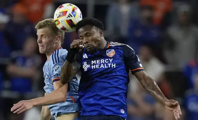 New York City FC midfielder Keaton Parks, left, and FC Cincinnati defender Alvas Powell, right, go up for the ball during the second half of a first-round soccer match of the MLS Cup playoffs, Monday, Oct. 28, 2024, in Cincinnati. (AP Photo/Carolyn Kaster)