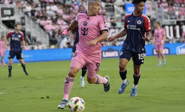 Inter Miami forward Luis Suarez (9) runs with the ball as New England Revolution midfielder Brandon Bye (15) defends during the first half of an MLS soccer match, Saturday, Oct. 19, 2024, in Fort Lauderdale, Fla. (AP Photo/Lynne Sladky)