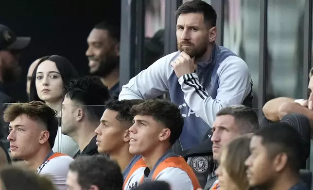 Inter Miami forward Lionel Messi watches from the bench during the first half of an MLS soccer match against the New England Revolution, Saturday, Oct. 19, 2024, in Fort Lauderdale, Fla. (AP Photo/Lynne Sladky)