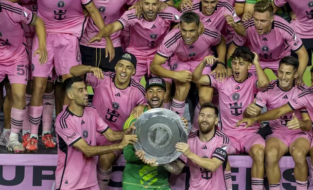 Inter Miami forward Lionel Messi, front, center right, celebrates with his teammates Sergio Busquets, front, center left, Luis Suárez, second row, left, and Drake Callender, center in green, after winning the Supporters' Shield, defeating the New England Revolution at Chase Stadium in Fort Lauderdale, Fla., Saturday, Oct. 19, 2024. (David Santiago/Miami Herald via AP)