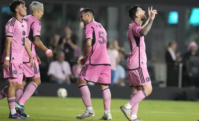 Inter Miami forward Lionel Messi, right, reacts after scoring his third goal for a hat trick during the second half of an MLS soccer match against the New England Revolution, Saturday, Oct. 19, 2024, in Fort Lauderdale, Fla. (AP Photo/Lynne Sladky)