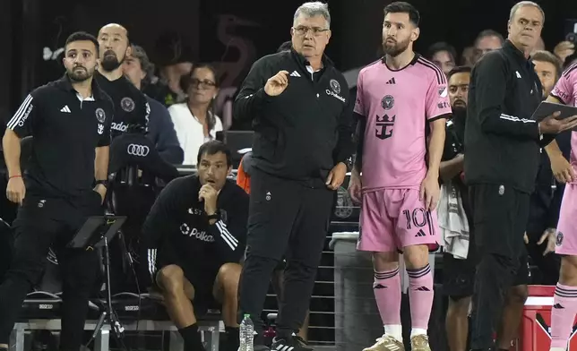 Inter Miami forward Lionel Messi (10) talks with head coach Gerardo "Tata" Martino during the second half of an MLS soccer match against the New England Revolution, Saturday, Oct. 19, 2024, in Fort Lauderdale, Fla. (AP Photo/Lynne Sladky)