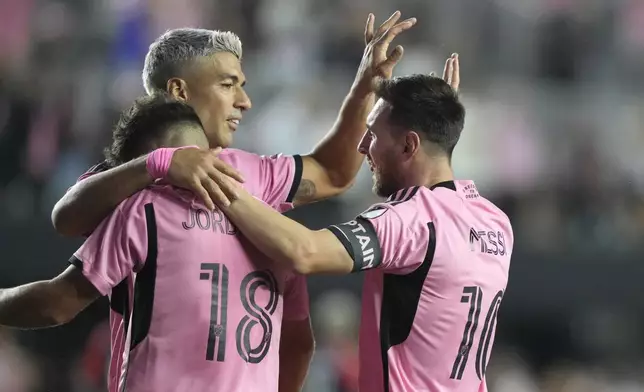 Inter Miami forward Lionel Messi (10) celebrates with Luis Suarez, center, and Jordi Alba (18) after scoring a goal during the second half of an MLS soccer match against the New England Revolution, Saturday, Oct. 19, 2024, in Fort Lauderdale, Fla. (AP Photo/Lynne Sladky)