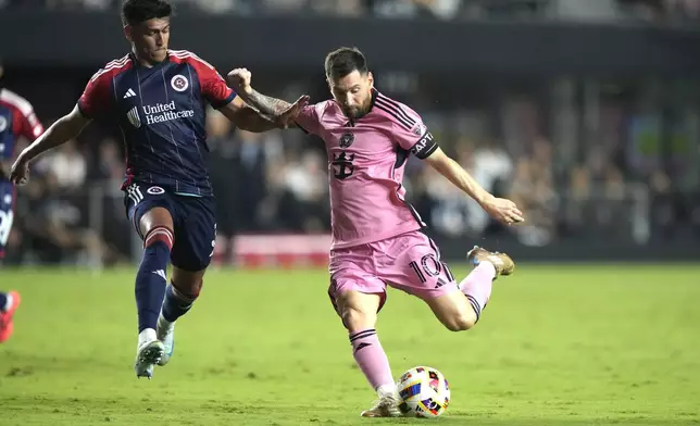 Inter Miami forward Lionel Messi (10) kicks the ball to score a goal as New England Revolution defender Xavier Arreaga, left, defends during the second half of an MLS soccer match, Saturday, Oct. 19, 2024, in Fort Lauderdale, Fla. (AP Photo/Lynne Sladky)