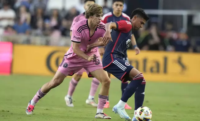 New England Revolution defender Xavier Arreaga, right, controls the ball as Inter Miami midfielder Benjamin Cremaschi, left, defends during the first half of an MLS soccer match, Saturday, Oct. 19, 2024, in Fort Lauderdale, Fla. (AP Photo/Lynne Sladky)