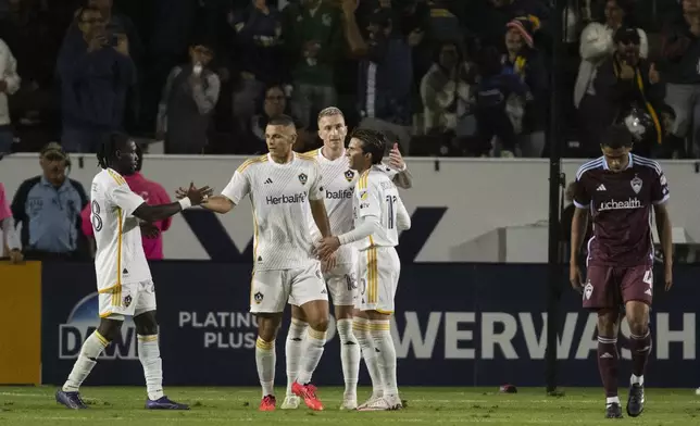 Los Angeles Galaxy forward Dejan Joveljić (9) celebrates his goal with forward Joseph Paintsil (28), midfielder Riqui Puig (10), and forward Marco Reus (18) during the second half of the first match of an MLS Cup playoffs opening round, Saturday against the Colorado Rapids, Oct. 26, 2024, in Carson, Calif. (AP Photo/Kyusung Gong)