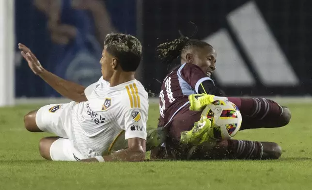 Colorado Rapids forward Kévin Cabral, right, and Los Angeles Galaxy midfielder Edwin Cerrillo slide for the ball during the second half of the first match of an MLS Cup playoffs opening round, Saturday, Oct. 26, 2024, in Carson, Calif. (AP Photo/Kyusung Gong)
