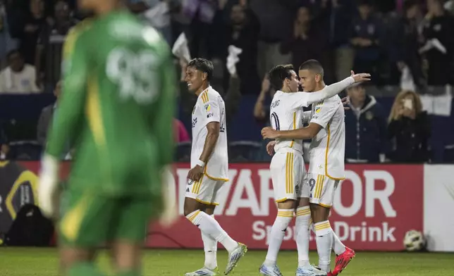 Los Angeles Galaxy forward Dejan Joveljić (9) celebrates his goal with midfielder Riqui Puig (10) during the first half of the first match of an MLS Cup playoffs opening round against the Colorado Rapids, Saturday, Oct. 26, 2024, in Carson, Calif. (AP Photo/Kyusung Gong)