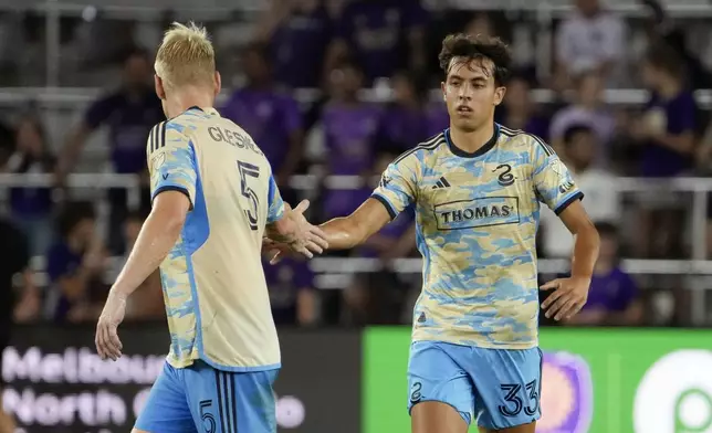 Philadelphia Union's Quinn Sullivan (33) celebrates his goal against Orlando City with teammate Jakob Glesnes (5) during the second half of an MLS soccer match, Wednesday, Oct. 2, 2024, in Orlando, Fla. (AP Photo/John Raoux)