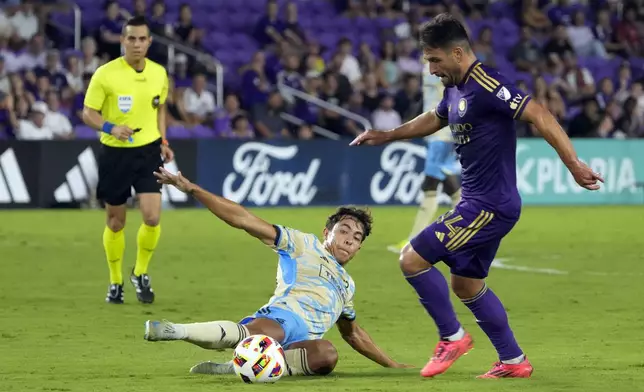 Philadelphia Union's Quinn Sullivan, left, tries to stop Orlando City's Nicolas Lodeiro (14) from advancing the ball during the second half of an MLS soccer match, Wednesday, Oct. 2, 2024, in Orlando, Fla. (AP Photo/John Raoux)