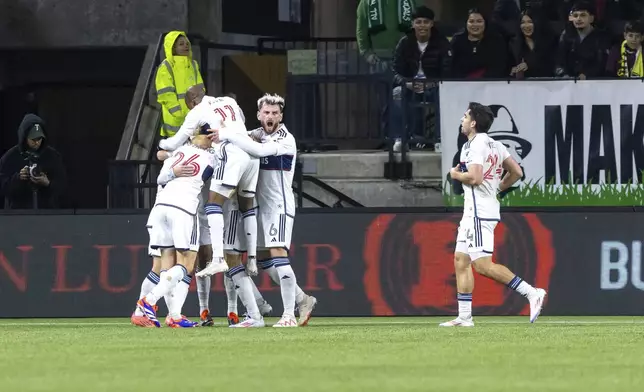 Vancouver Whitecaps players celebrate after midfielder Ryan Gauld's goal during the first half oa an MLS playoff match against the Portland Timbers on Wednesday, Oct. 23, 2024 in Portland, Ore. (Sean Meagher/The Oregonian via AP)