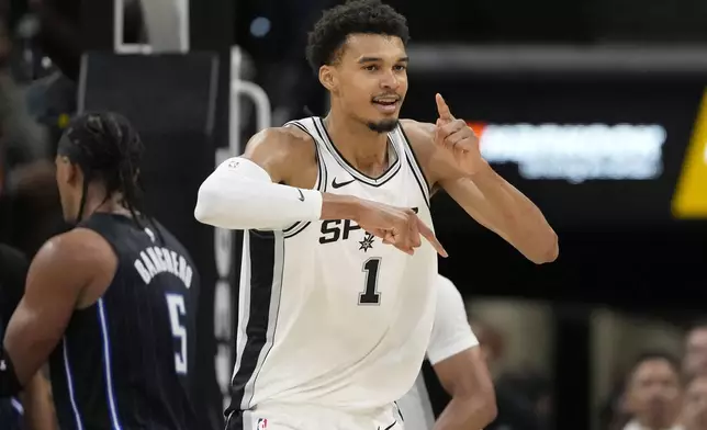 San Antonio Spurs center Victor Wembanyama (1) reacts to a score against the Orlando Magic during the first half of a preseason NBA basketball game in San Antonio, Wednesday, Oct. 9, 2024. (AP Photo/Eric Gay)