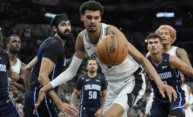 San Antonio Spurs center Victor Wembanyama (1) chases a loose ball after he was blocked during the second half of a preseason NBA basketball game against the Orlando Magic in San Antonio, Wednesday, Oct. 9, 2024. (AP Photo/Eric Gay)