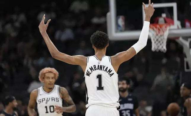 San Antonio Spurs center Victor Wembanyama (1) reacts to a score against the Orlando Magic during the first half of a preseason NBA basketball game in San Antonio, Wednesday, Oct. 9, 2024. (AP Photo/Eric Gay)