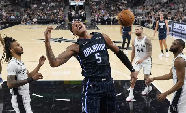 Orlando Magic forward Paolo Banchero (5) scores against the San Antonio Spurs during the first half of a preseason NBA basketball game in San Antonio, Wednesday, Oct. 9, 2024. (AP Photo/Eric Gay)