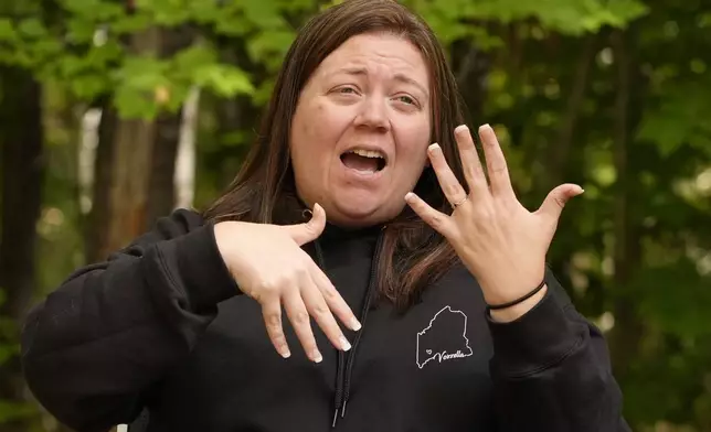 Megan Vozzella uses sign language during an interview about her late husband, Stephen Vozzella, who was one of the people killed in a mass shooting on Oct. 25, 2023, in Lewiston, Tuesday, Oct. 1, 2024, in Oxford, Maine. (AP Photo/Robert F. Bukaty)