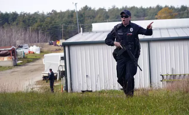 FILE - A police officer gives an order to the public during a manhunt for Robert Card at a farm following two mass shootings, in this Oct. 27, 2023 file photo, in Lisbon, Maine. (AP Photo/Robert F. Bukaty, File)