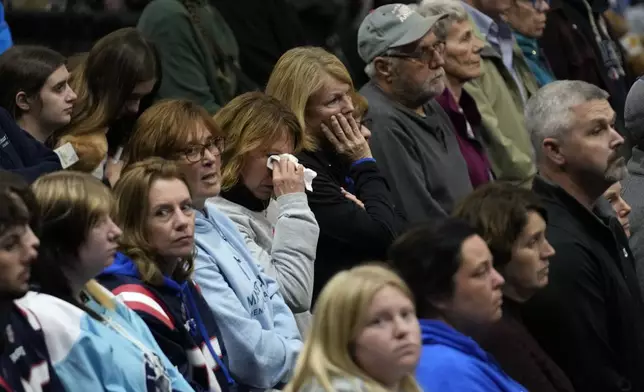 A woman wipes tears during the playing of Amazing Grace at a commemoration event to mark the one year anniversary of the mass shooting in Lewiston, Maine, Friday, Oct. 25, 2024. (AP Photo/Robert F. Bukaty)