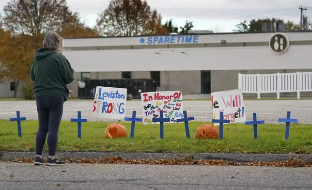 FILE - A woman visits a makeshift memorial outside Sparetime Bowling Alley, the site of a mass shooting, in this Oct. 28, 2023 file photo, in Lewiston, Maine. (AP Photo/Robert F. Bukaty, File)