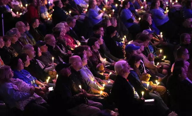 Attendees hold candle lights at a commemoration event to mark the one year anniversary of the mass shooting in Lewiston, Maine, Friday, Oct. 25, 2024. (AP Photo/Robert F. Bukaty)