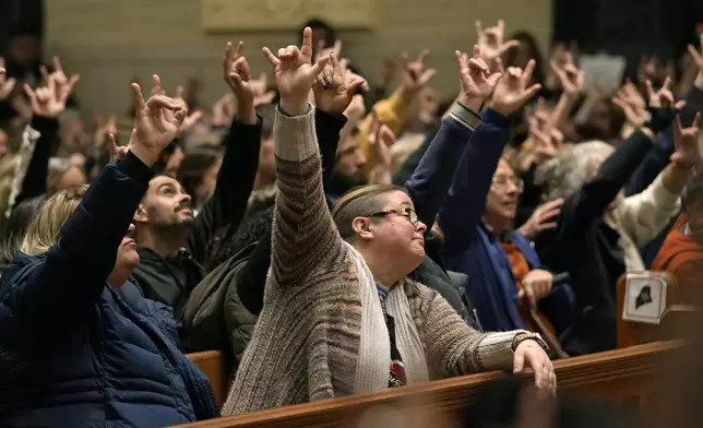 FILE - In this Sunday, Oct. 29, 2023 file photo, mourners sign "I love you" at a vigil for the victims of Wednesday's mass shootings at the Basilica of Saints Peter and Paul, in Lewiston, Maine. (AP Photo/Robert F. Bukaty, files)