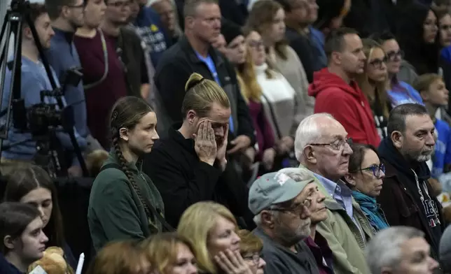 Attendees stand during the playing of Amazing Grace at a commemoration event to mark the one year anniversary of the mass shooting in Lewiston, Maine, Friday, Oct. 25, 2024. (AP Photo/Robert F. Bukaty)