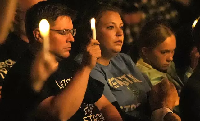 Attendees observe a moment of silence at a commemoration event to mark the one year anniversary of the mass shooting in Lewiston, Maine, Friday, Oct. 25, 2024. (AP Photo/Robert F. Bukaty)