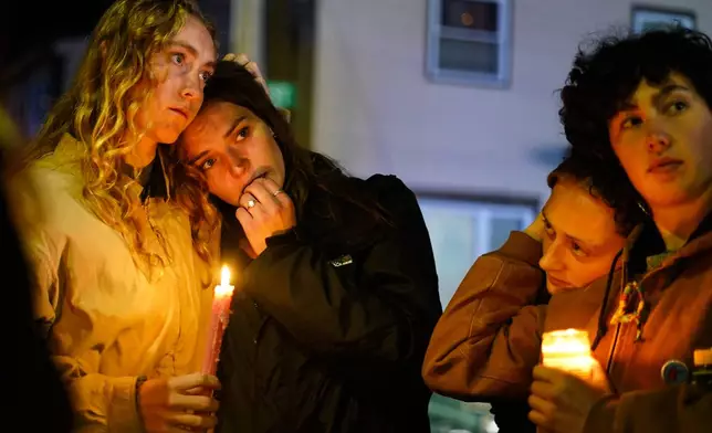 FILE - People linger after a vigil for the victims of Wednesday's mass shootings, Oct. 29, 2023, outside the Basilica of Saints Peter and Paul in Lewiston, Maine. (AP Photo/Matt Rourke, File)