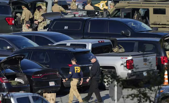 FILE - Law enforcement personnel are staged in a school parking lot during a manhunt for Robert Card in the aftermath of a mass shooting in Lewiston, Maine, Oct. 27, 2023. (AP Photo/Matt Rourke, File)