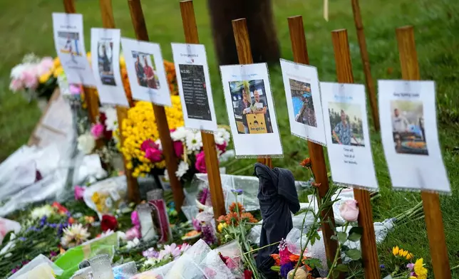 FILE - Rain-soaked memorials for those who died in a mass shooting sit along the roadside by Schemengees Bar &amp; Grille, Oct. 30, 2023, in Lewiston, Maine. (AP Photo/Matt York, File)