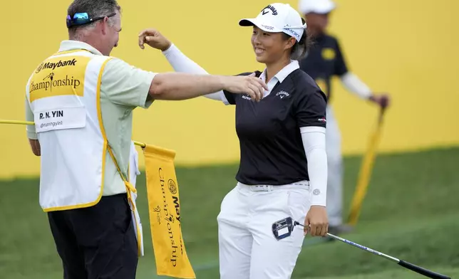 Yin Ruoning of China celebrates with his caddie on the 18th hole after winning the LPGA Tour's Maybank Championship at Kuala Lumpur Golf and Country club in Kuala Lumpur, Sunday, Oct. 27, 2024. (AP Photo/Vincent Thian)