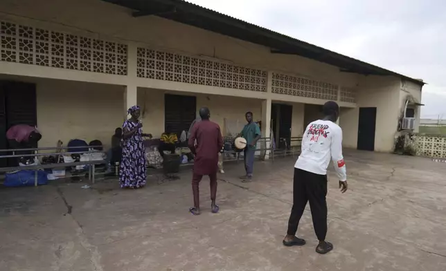 Mamadou Diarra, right, dances with other patients at Bamako's Point G hospital psychiatric ward in the hospital's courtyard in Bamako, Mali, Friday, Sept. 20, 2024. (AP Photo/Moustapha Diallo)