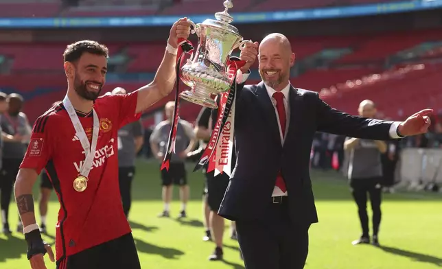 FILE - Manchester United's head coach Erik ten Hag and Manchester United's Bruno Fernandes pose with the trophy after winning the English FA Cup final soccer match between Manchester City and Manchester United at Wembley Stadium in London, Saturday, May 25, 2024. (AP Photo/Ian Walton, File)